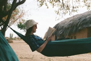 Film photo of a young woman reading inside a hammock