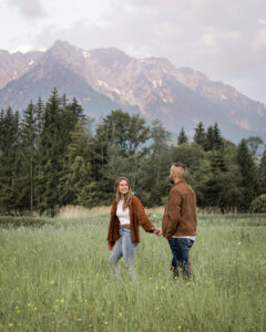 Young couple walking at sunrise with the pink mountain peaks of the Wilder Kaiser in the background