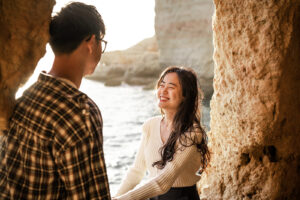 Young woman laughing warmly toward her partner in the opening of a Portuguese cave