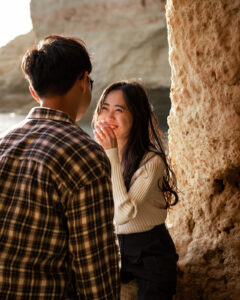 Young Korean woman laughing while covering her mouth with her hand