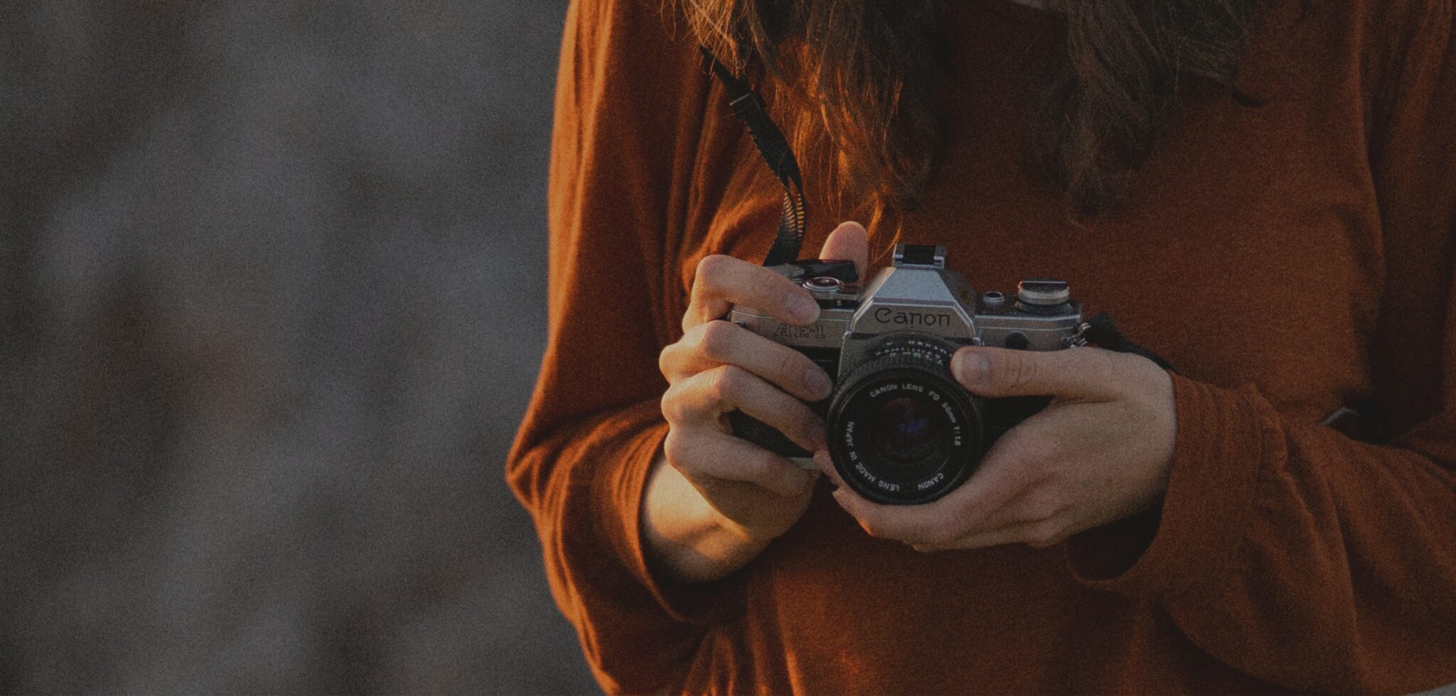 Close-up photo showing hands holding a film camera