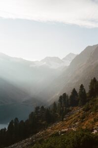 Film photo of the Tyrolean mountains as sun rays stream through the mountain peaks into the valley