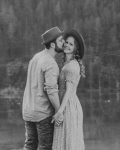 Vintage blurry black-and-white photo of a man kissing his girlfriend on the cheek