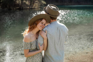 Woman holding onto her partner’s arm while gazing dreamily into nature