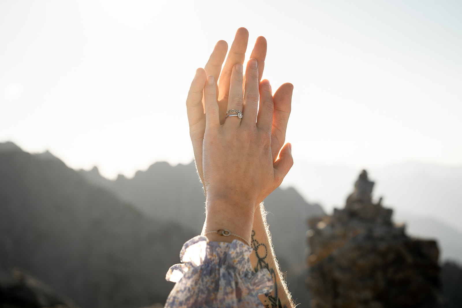 Close-up of intertwined hands with focus on the engagement ring