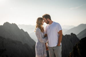 Woman holding onto her partner’s arm while both lean their heads together and smile