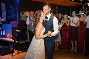 The bride rests her head on her husband’s shoulder during the wedding dance