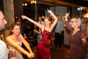 The bridesmaid dances with her hands raised