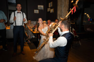 The groom plays an instrument while the bride drums on it and laughs