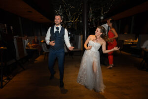 The wedding couple plays air guitar on the dance floor