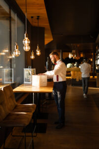 Distant shot of a guest placing something on the table