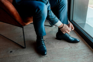 Close-up of the groom’s hands tying his shoes