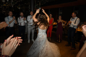 The wedding couple dances while the groom holds the instrument