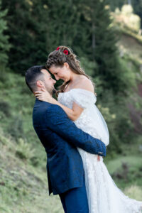 The groom lifts his bride as their foreheads touch