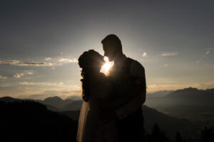 Silhouette photo of a wedding couple at sunset with mountains in the background