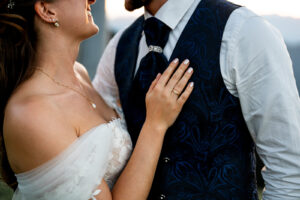 Close-up of the bride resting her hand on the groom’s chest
