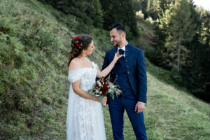 The groom smiles at his bride as she holds and looks at his tie