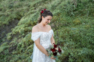 The bride walks along a path, smiling and looking down