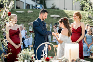 The bride places the wedding ring on the groom’s finger