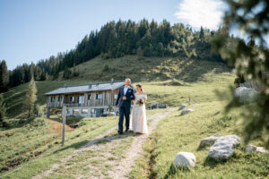 Bride and father walk together to the outdoor wedding ceremony