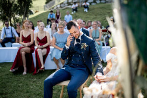 The groom wipes tears from his face during the ceremony