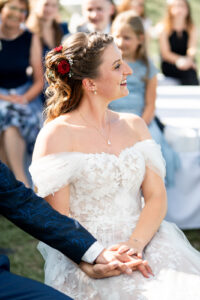 Portrait of the bride during the ceremony holding the groom’s hand