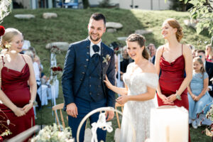 Bride and groom laugh during the ceremony as she holds onto his chest