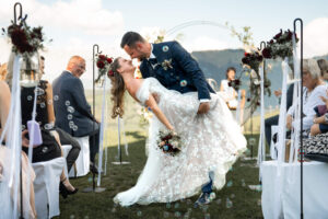 Dip pose of the wedding couple in the aisle surrounded by soap bubbles