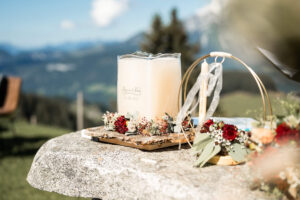 Close-up of the wedding candle beside the rings on the ribbon