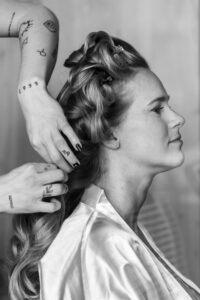 Black and white photo of the bride's hair being styled