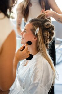 Side view of the bride during hair and makeup styling