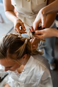 Top-down view of the bride's hair being braided and styled