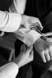 Close-up of the best man attaching the cufflinks to the shirt