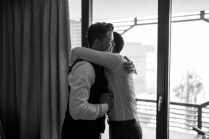 Black and white photo of a hug between the groom and his best man
