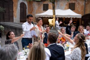 Wedding guests raising a toast together across the dinner table after the speeches