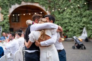 Emotional group hug between the couple and their wedding attendants