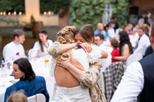 Maid of honor and bride sharing an emotional hug after the speech