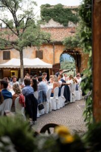Wedding guests seated together at a beautifully decorated dinner table in the Castle Rametz courtyard