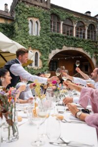 Groom toasting with his guests across the wedding dinner table