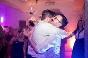Groom hugging a wedding guest on the dance floor