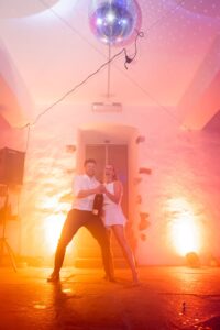 Bride and groom popping a bottle together on the dance floor
