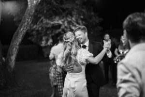 Black and white photo of a bride and groom dancing a romantic waltz