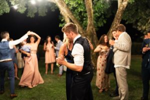 Groom dancing with his mother while guests watch in the background