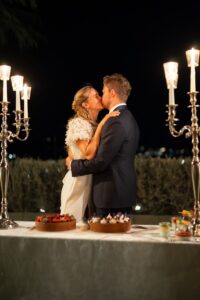 Bride and groom sharing a kiss after cutting their wedding cake