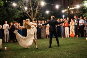 Bride and groom leaning to the side while dancing as the wedding dress flows through the air