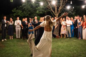 Bride and groom raising their arms during their first dance while guests watch