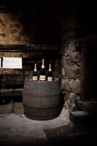 Wine bottles displayed on a wooden barrel inside the wine cellar of Castle Rametz