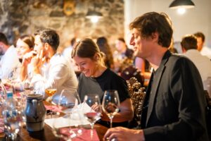Wedding guests sitting together at a wine tasting table and sharing a laugh