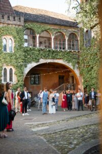 Wedding guests gathered in the courtyard of Castle Rametz surrounded by ivy-covered walls