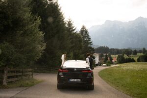 Warm vintage photo of a wedding couple leaning out of a car window